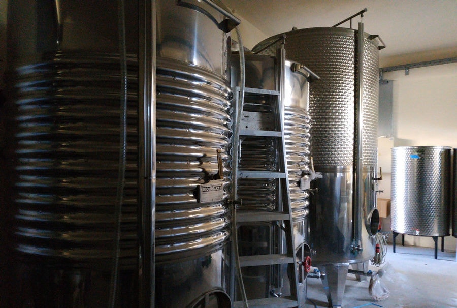 lying wooden barrels in a row at Liepouris Winery plant